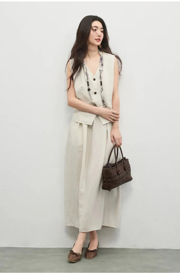 Woman in a lyocell-blend vest and skirt set, moving through her day while holding a bag — From Borcelleclothes.