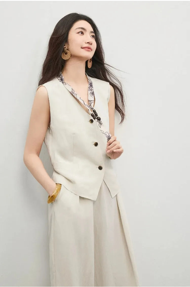 A woman’s hand gently touching the delicate tie with wooden beads — From Borcelleclothes.