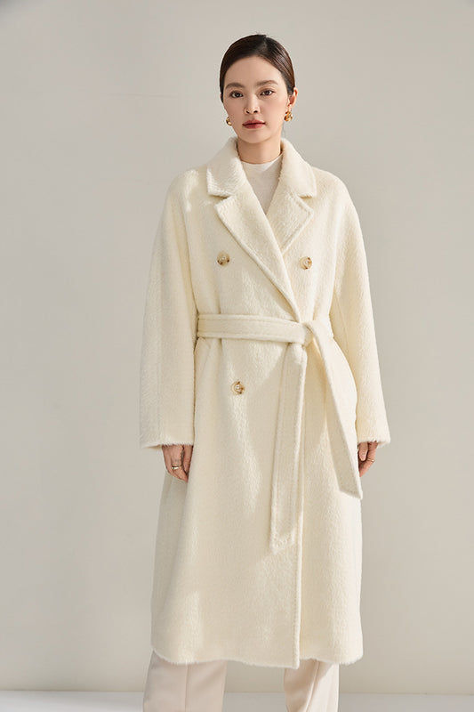 A woman stands straight wearing the mid-calf alpaca wool coat in Bare Necessity cream, showcasing its structured double-breasted silhouette. From Borcelleclothes.