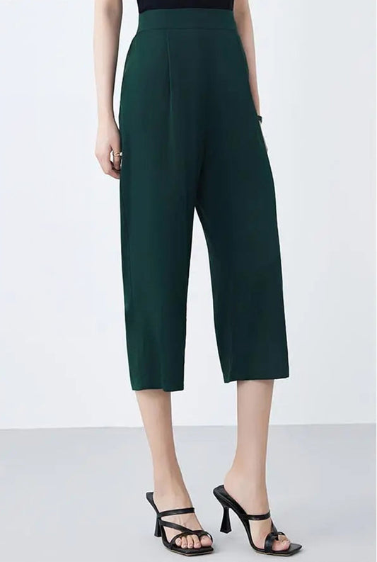 Model wearing mid-calf Mulberry silk trousers in Cyber Jade, turned slightly to the side — From Borcelleclothes.