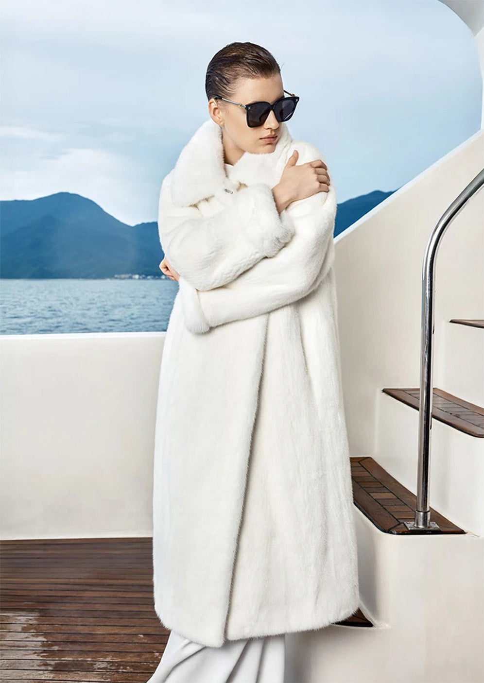 Model in White Echo mink coat touching shoulder, gaze turned softly to the side, collar raised. — From Borcelleclothes.