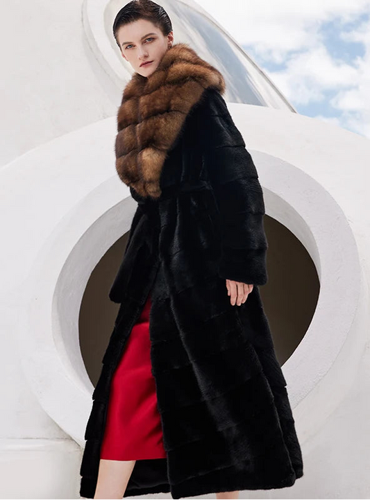 Women’s full-length wrap mink coat in Beyond Black with a burnished amber sable collar. Features a flared silhouette, mink belt, and horizontal paneling. — From Borcelleclothes.