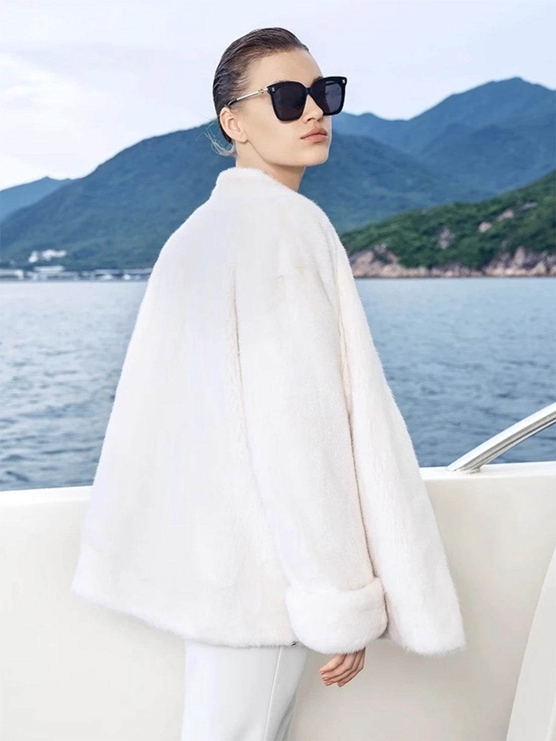 Side view of model in Pale Reverie mink coat with turned-back cuffs and straight silhouette — From Borcelleclothes.