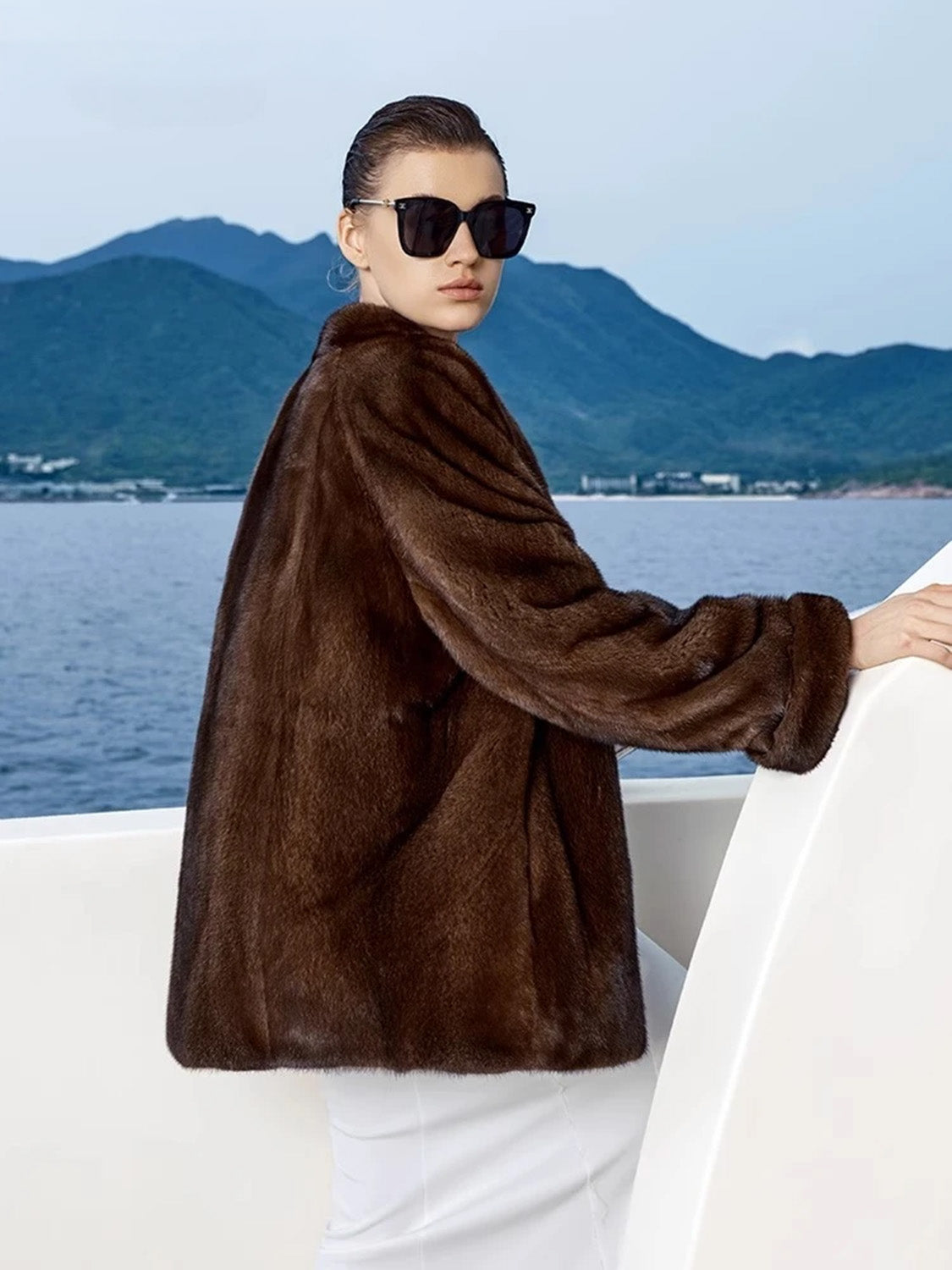 Profile view of woman in Trace of Clove mink coat with relaxed fit and discreet pocket detail — From Borcelleclothes.