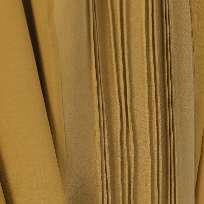 Close-up of the refined pintuck detail groups on the Aztec Gold silk skirt panel, highlighting craftsmanship — From Borcelleclothes.