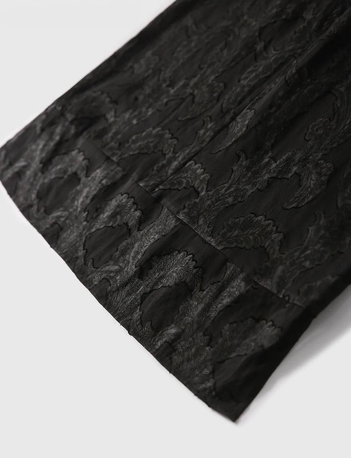 Flat-lay view of the lower hem on the Mulberry Silk Blouse in Bittersweet Noir, showcasing the seamless weave structure — From Borcelleclothes.