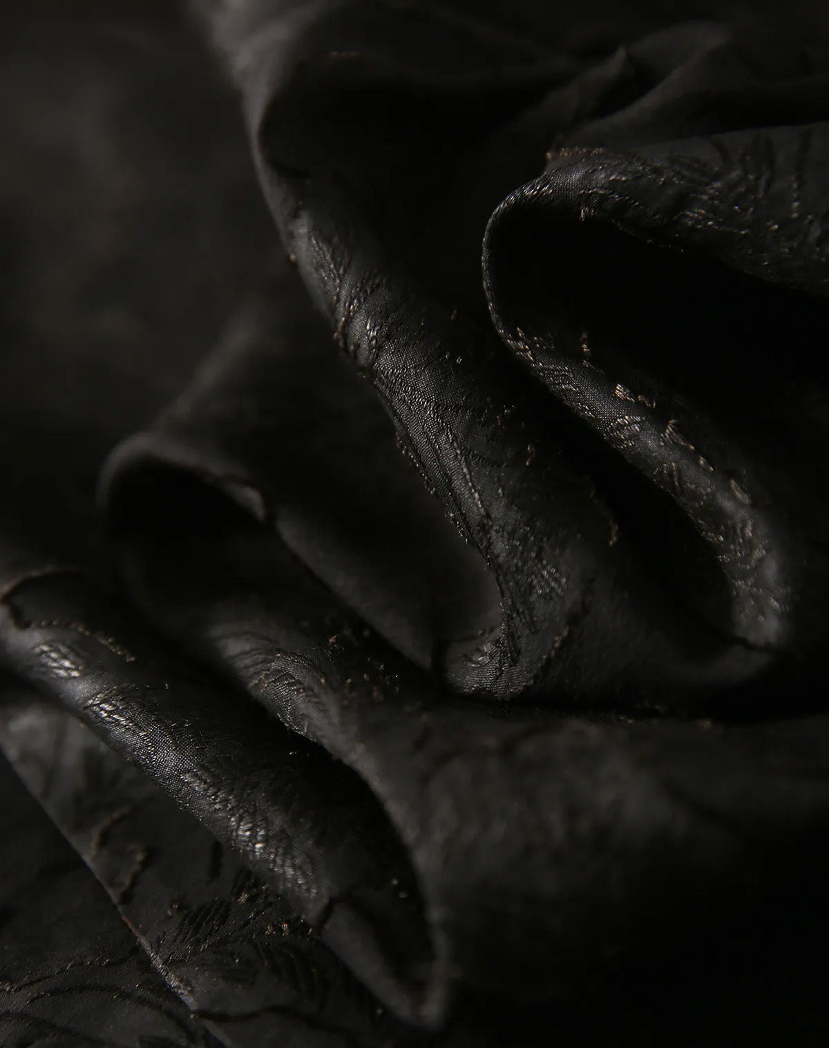 Serpentine soft folds of the Mulberry Silk Blouse in Bittersweet Noir, capturing the play of light across the embossed leaves — From Borcelleclothes.