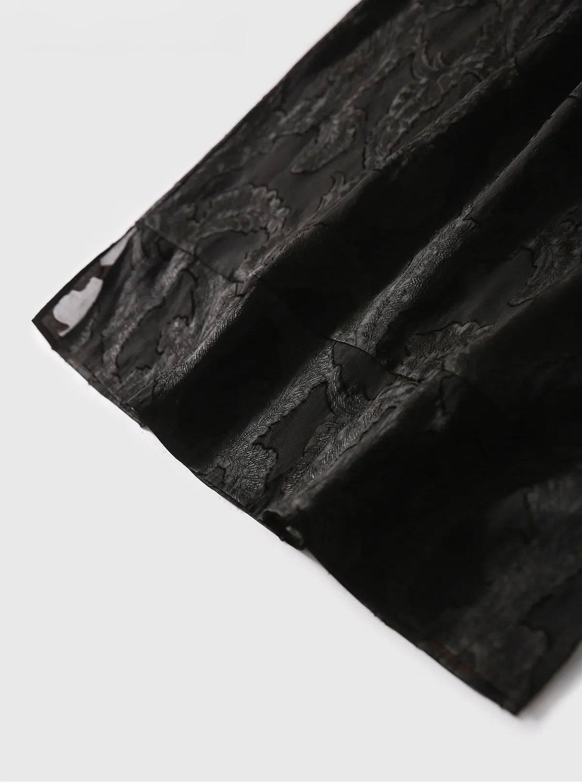 Artistic wave-folded hem of the Mulberry Silk Blouse in Bittersweet Noir, showing fluid silk drape and lustrous leaf motifs — From Borcelleclothes.