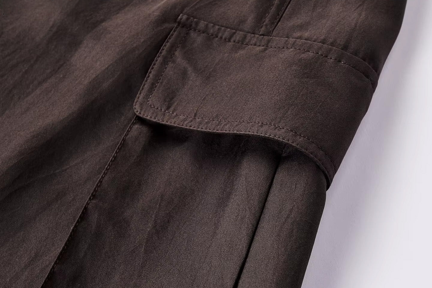 Close-up of an oversized side cargo pocket with a flap on a premium Mulberry silk poplin skirt — From Borcelleclothes.