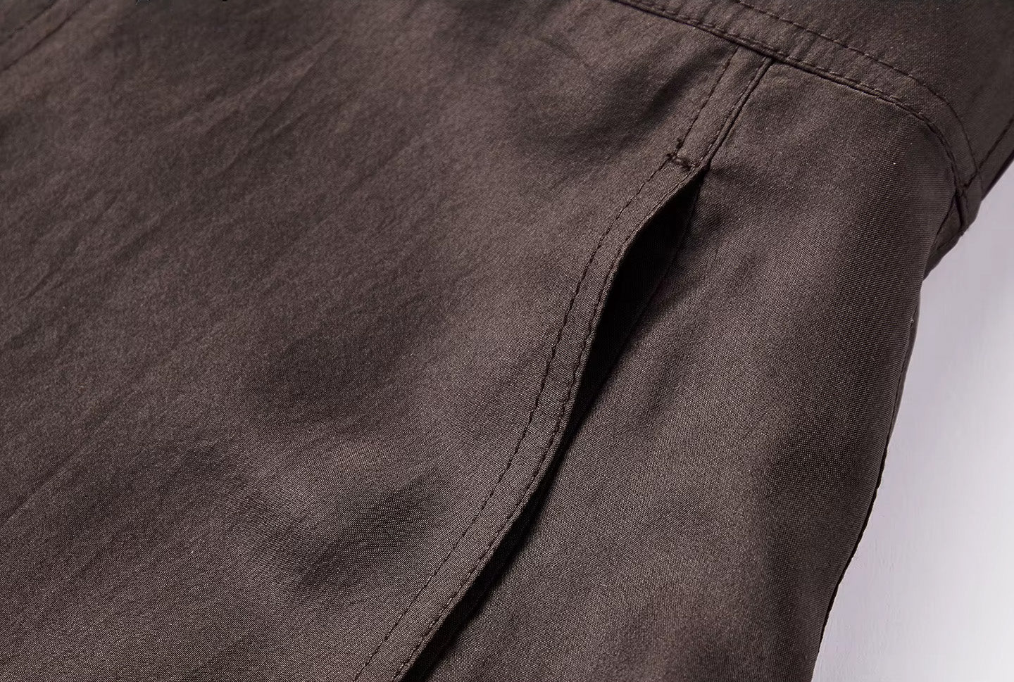 Detailed shot of a convenient in-seam pocket integrated into the double-topstitched panel seams of a silk skirt — From Borcelleclothes.