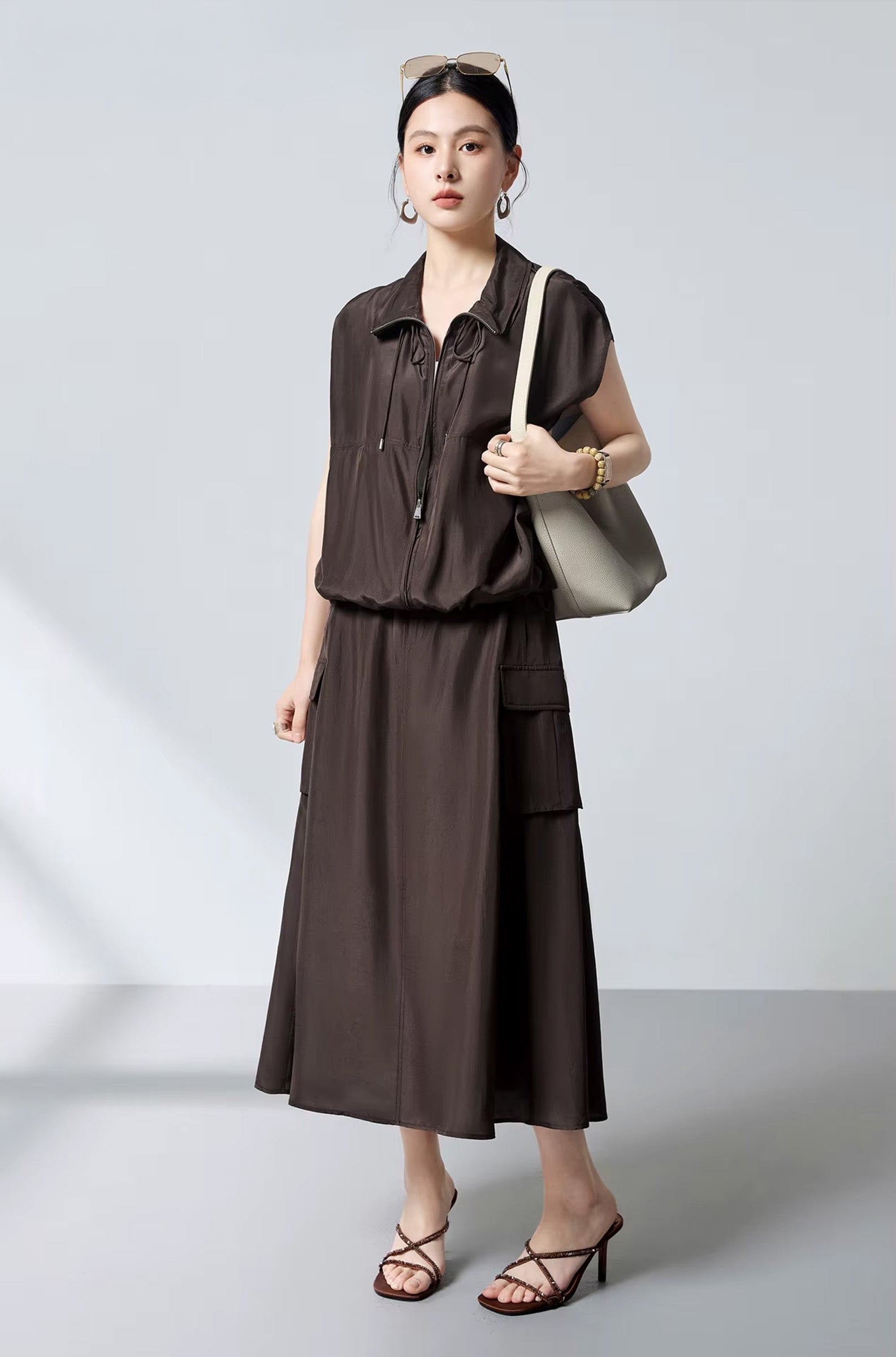 Total look in Bitter Chocolate silk featuring a flared cargo skirt, with a model with a bag over the shoulder — From Borcelleclothes.