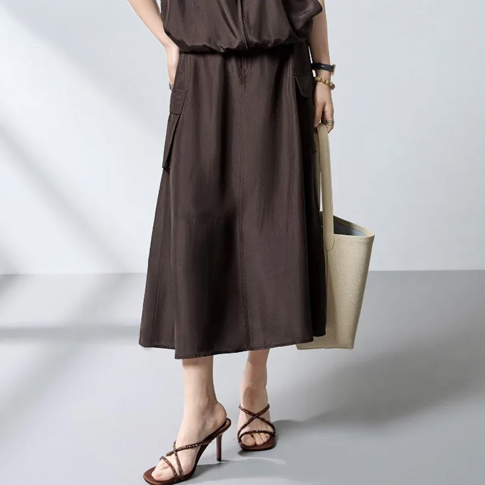 Model with a hand on the hip, posing in a Bitter Chocolate Mulberry silk cargo skirt and matching top — From Borcelleclothes.