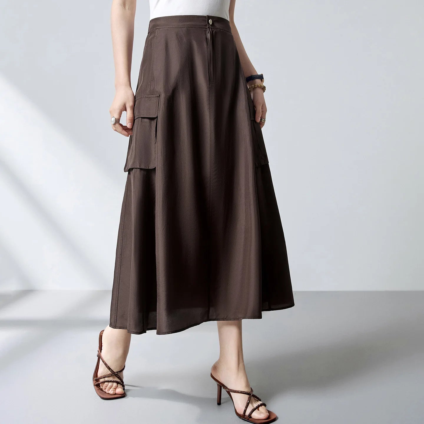 Women's flared midi cargo skirt crafted from premium Grade 6A Mulberry silk poplin in Bitter Chocolate. Features structured panel seam pockets and an elasticated back. — From Borcelleclothes.