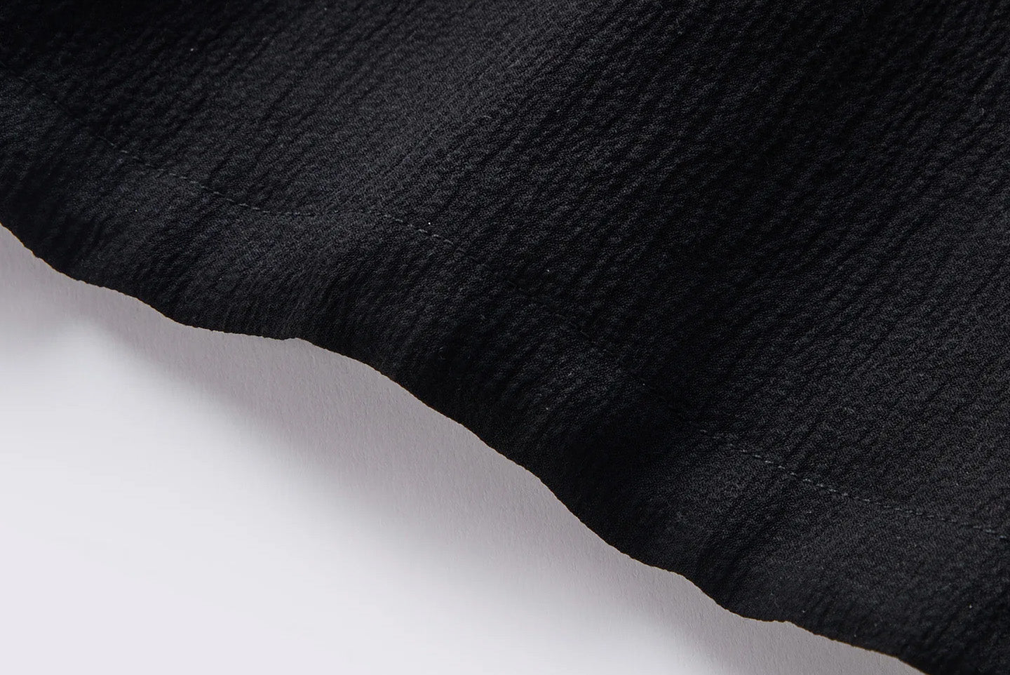Close-up of the clean-finished bottom hem and crinkled 3D silk texture in Melting Evening — From Borcelleclothes.