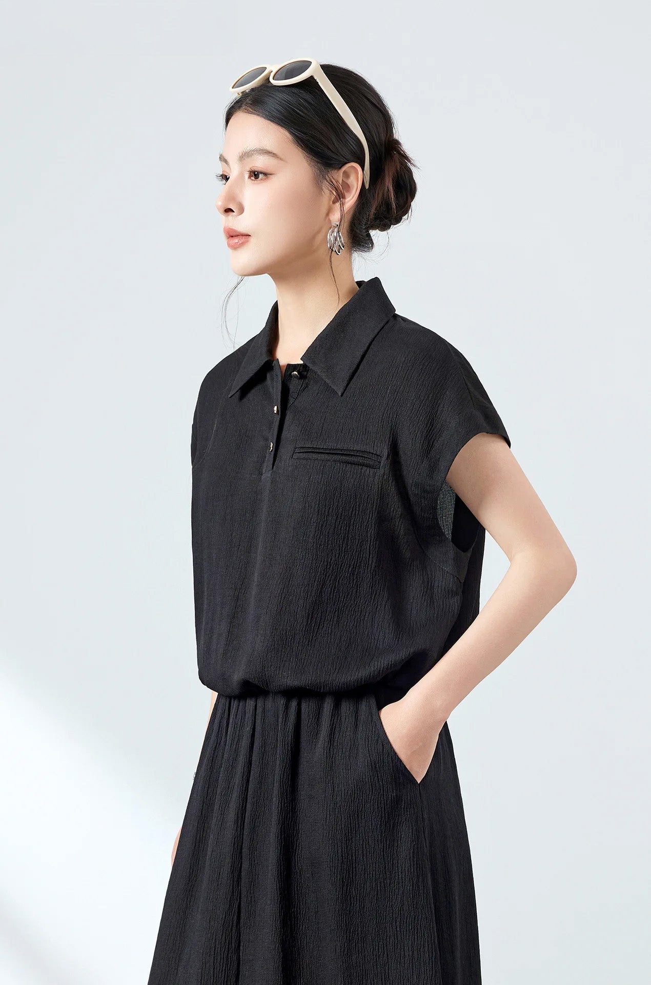 Close-up of the silk crinkled polo shirt tucked into a skirt pocket in Melting Evening — From Borcelleclothes.