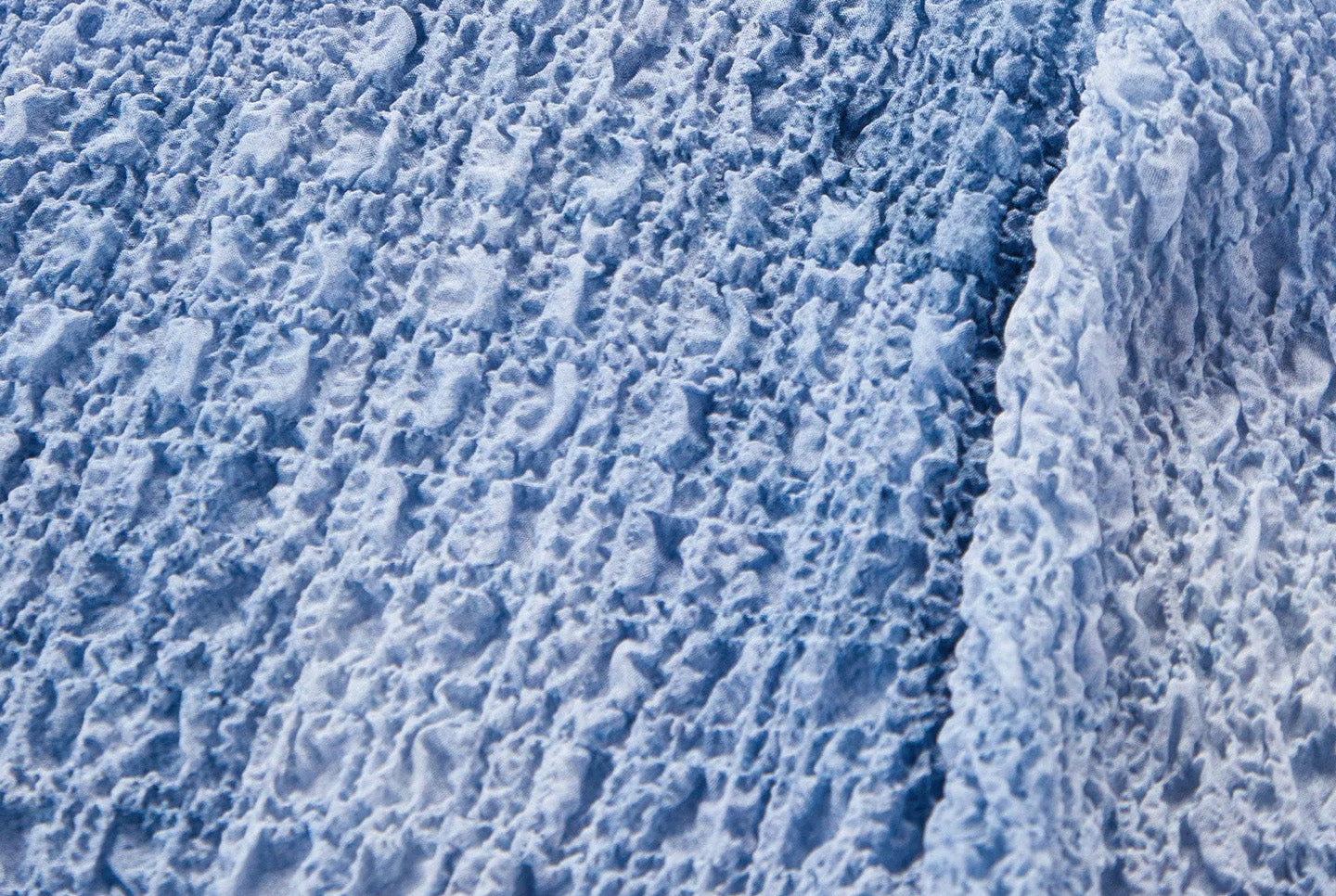 Close-up of the clean armhole seam craftsmanship on the Cloudy Sky puckered silk top — From Borcelleclothes.