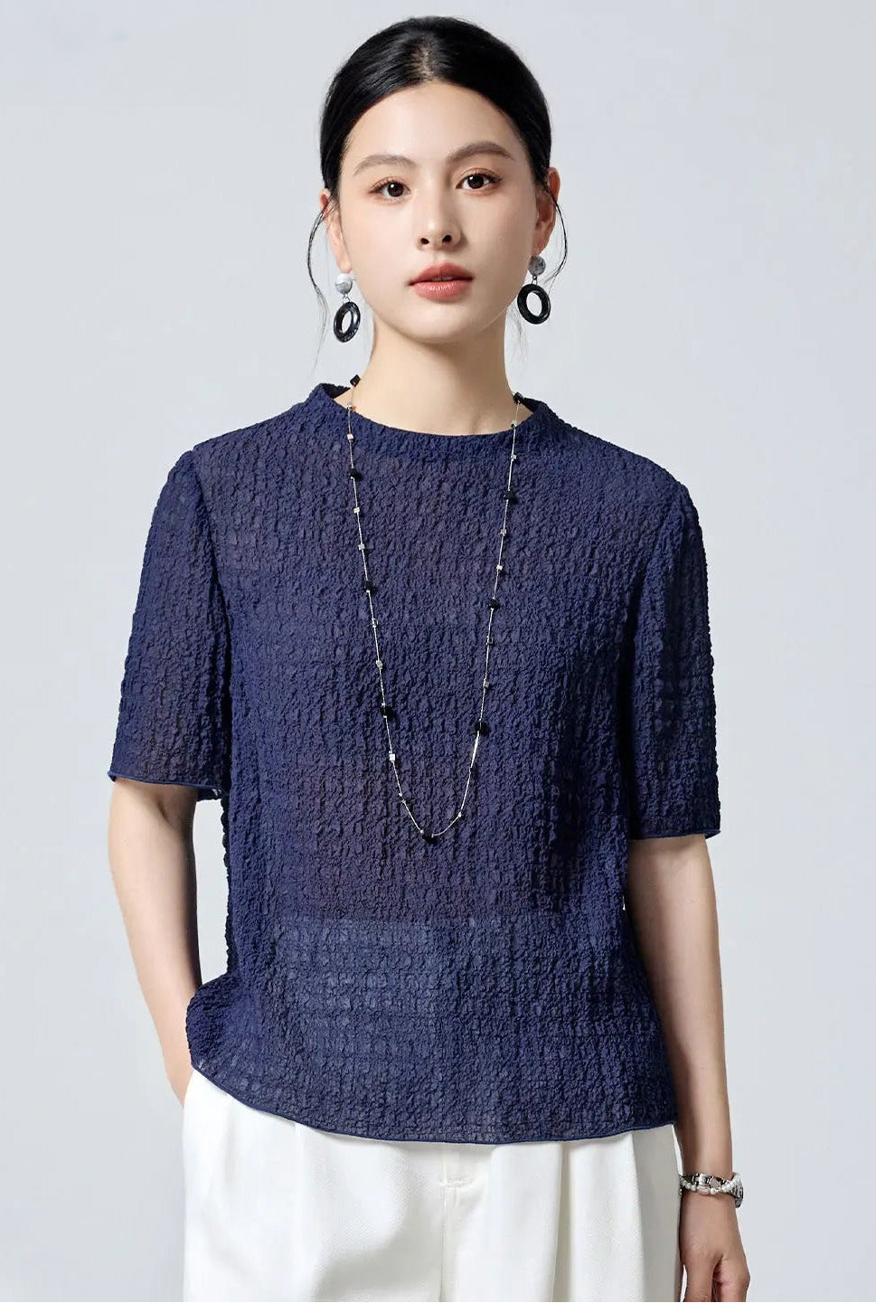 Model posing with hand in pocket in the slate-indigo Sagittarius mulberry silk jacquard top — From Borcelleclothes.
