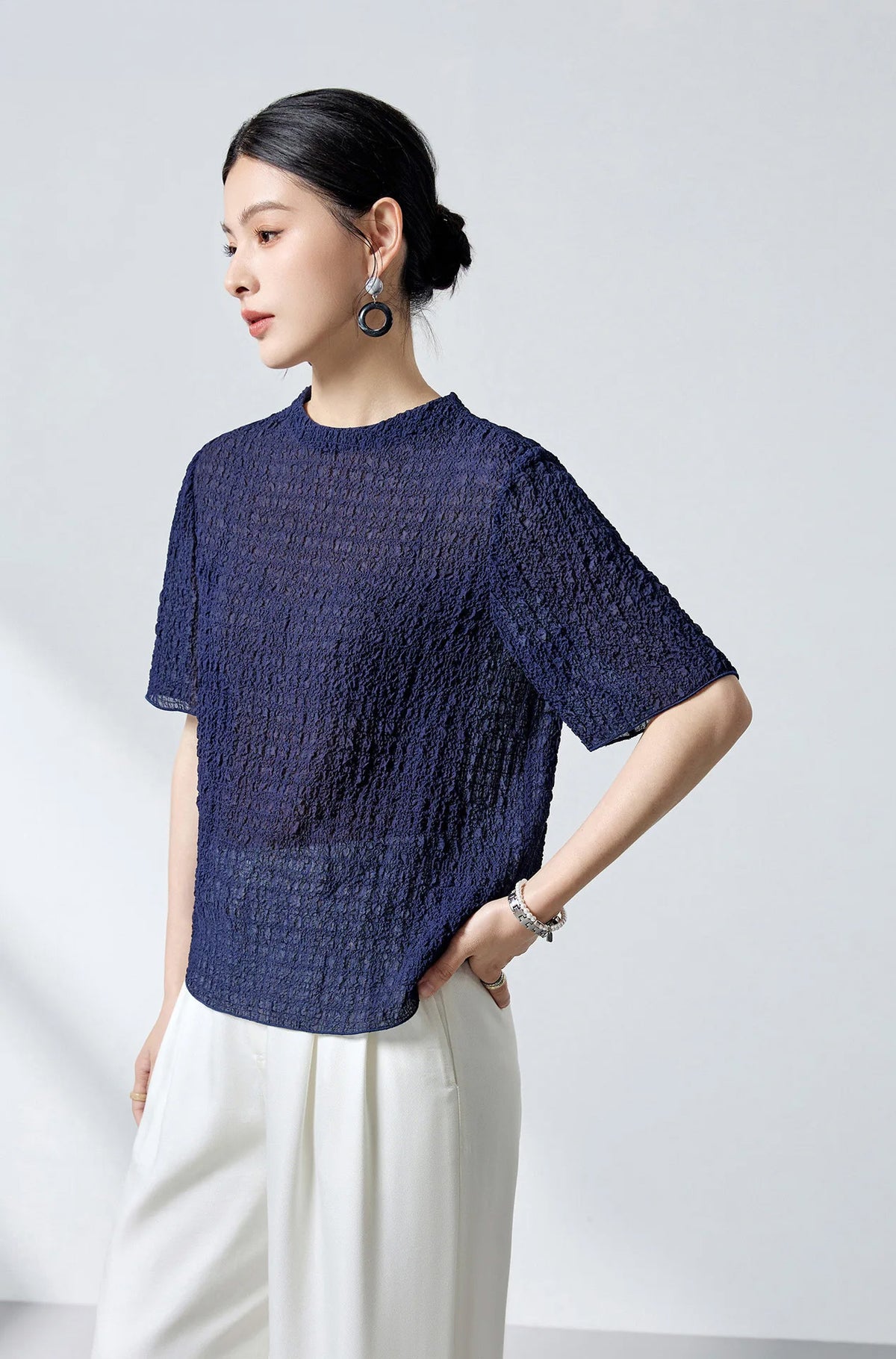Side profile of a model wearing the Sagittarius mulberry silk 3D jacquard top — From Borcelleclothes.