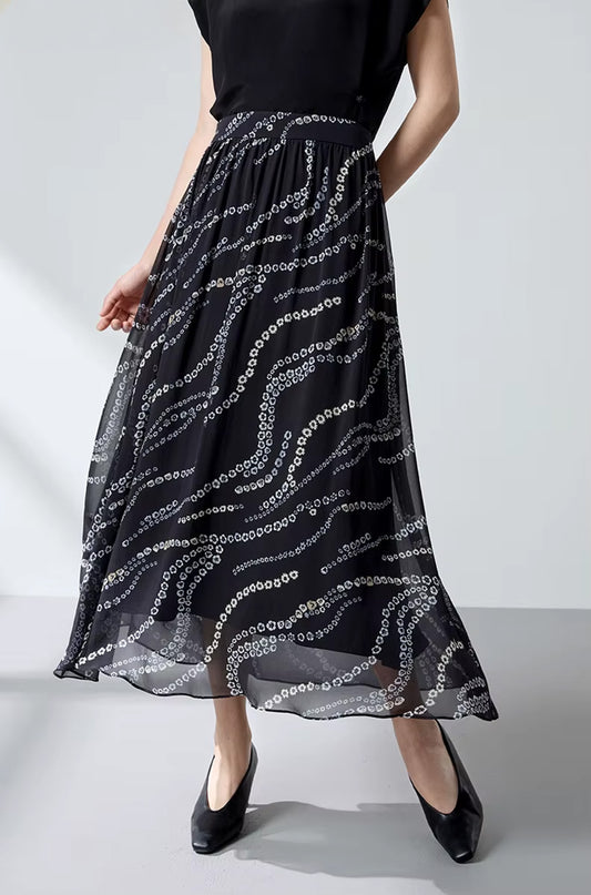 A model in motion wearing a black Mulberry silk skirt with a floral pattern, one hand behind her back — From Borcelleclothes.