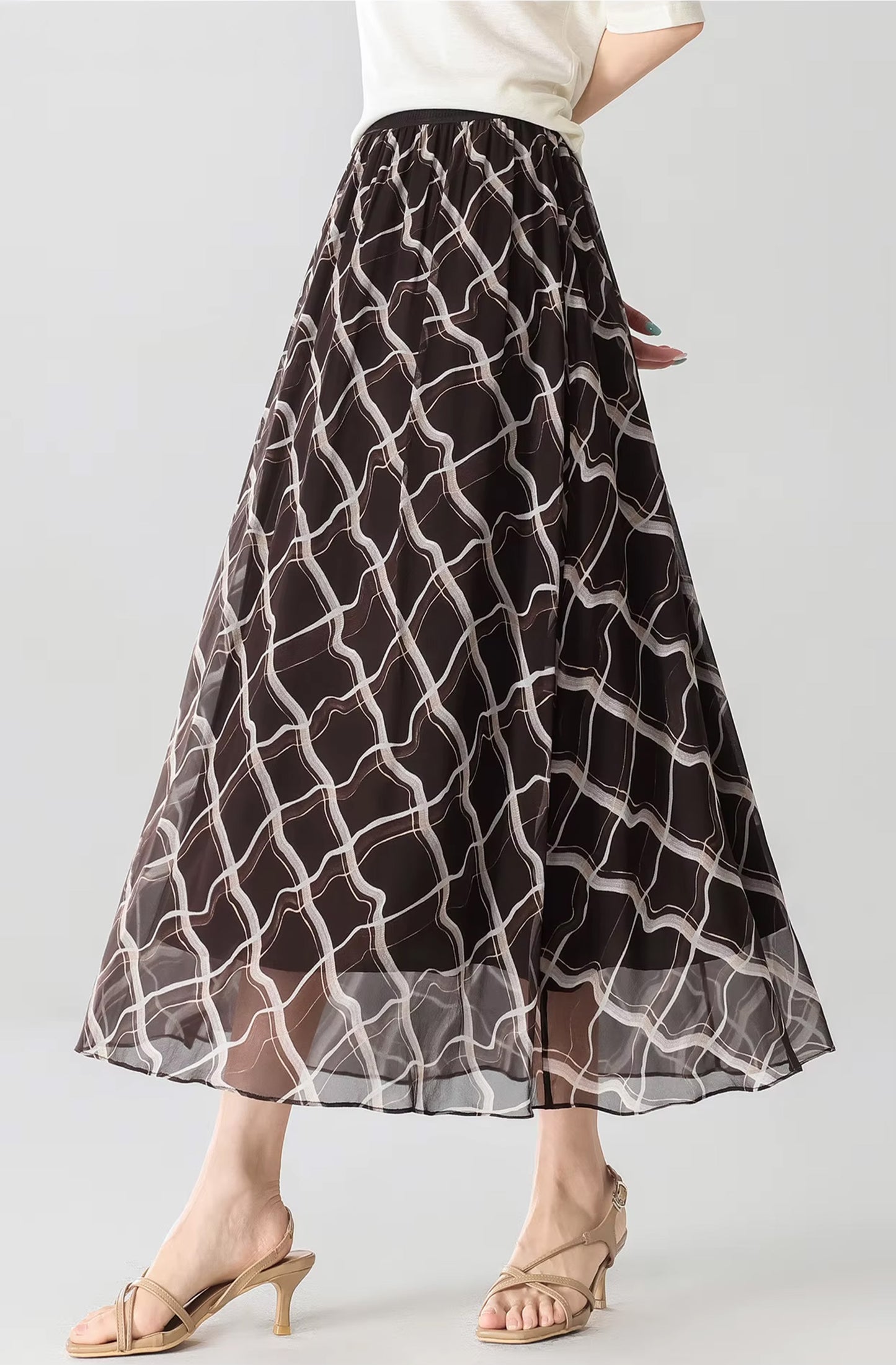 Model posing with hands behind her back in the Café Mirage silk midi skirt — From Borcelleclothes.