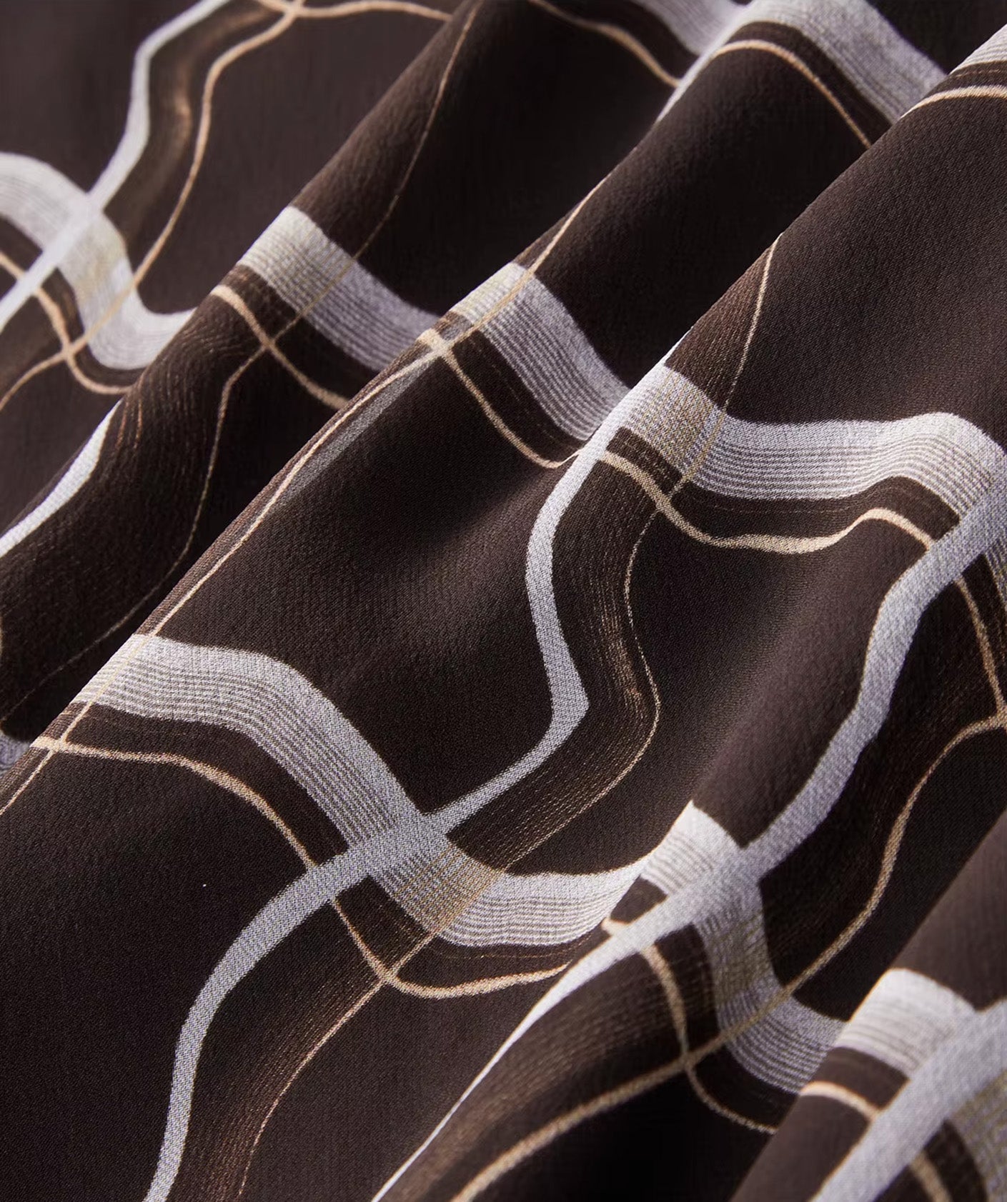 Close-up of the fluid wave-folded texture of the Café Mirage silk georgette skirt showing the immersive 3D ribbon pattern — From Borcelleclothes.