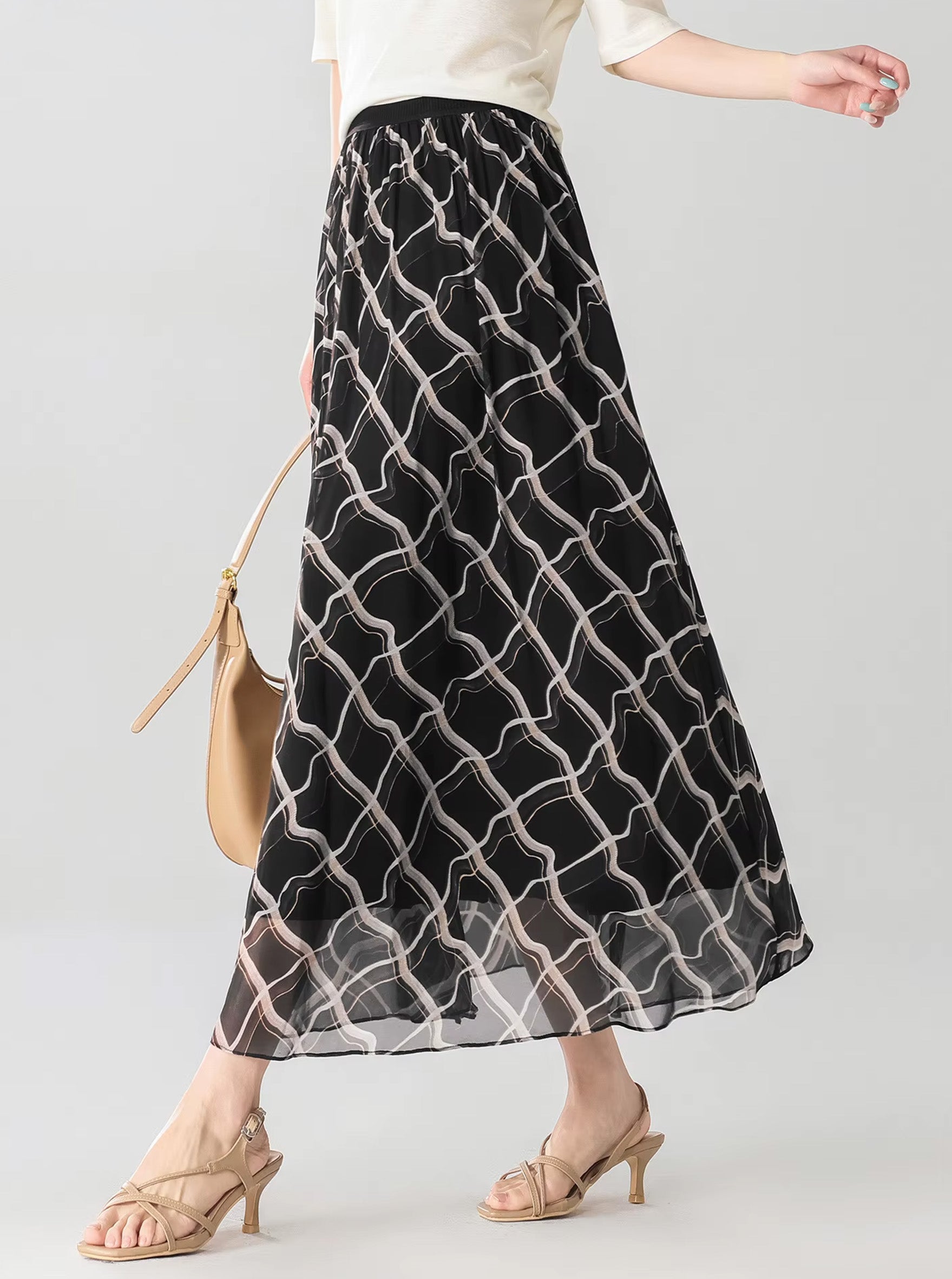 Side view of a model walking in the Night Hallucination black Mulberry silk midi skirt with geometric rhombus print — From Borcelleclothes.