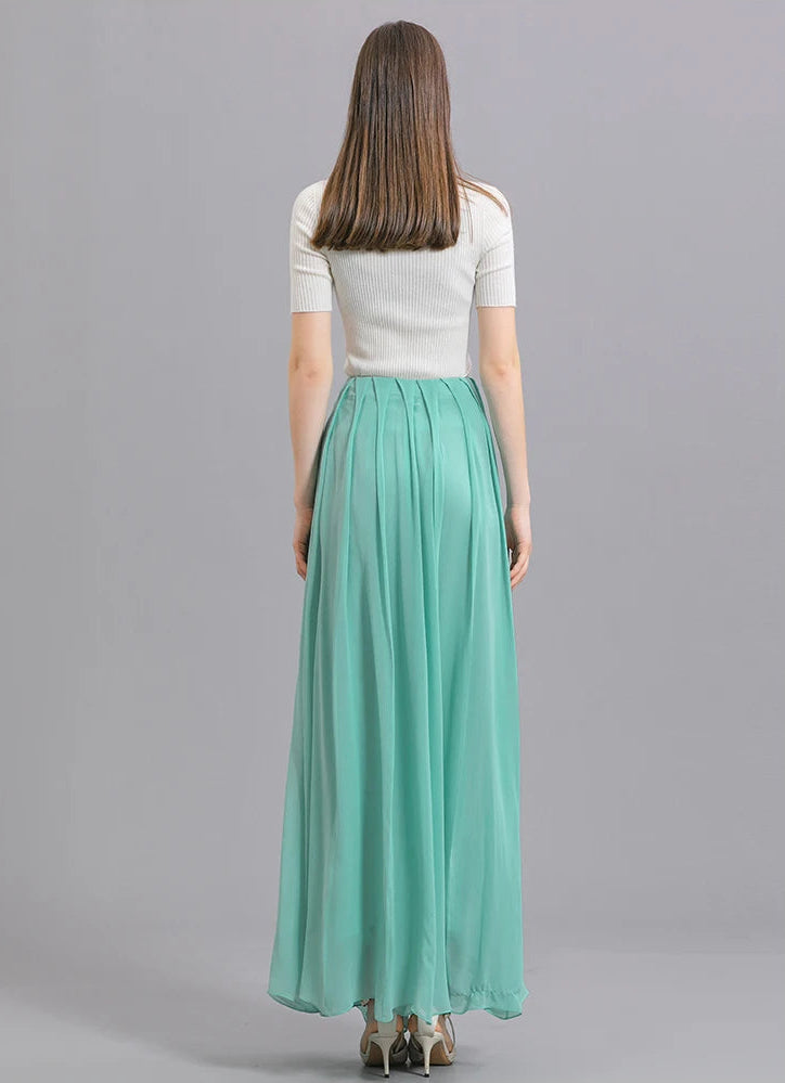Full-height back view of a model wearing a women's Mulberry silk skirt with spread pleats in Cross Waves — From Borcelleclothes.