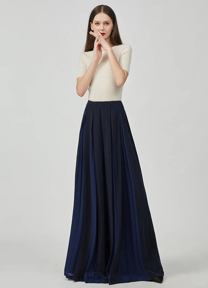 Women's Mulberry silk trousers with georgette inserts in Vortex Flower, featuring a model posing with crossed fingers near her face — From Borcelleclothes.