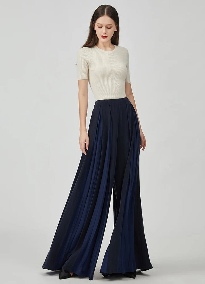 Women's Mulberry silk trousers with georgette inserts in Vortex Flower, featuring a model looking down and posing her foot aside — From Borcelleclothes.