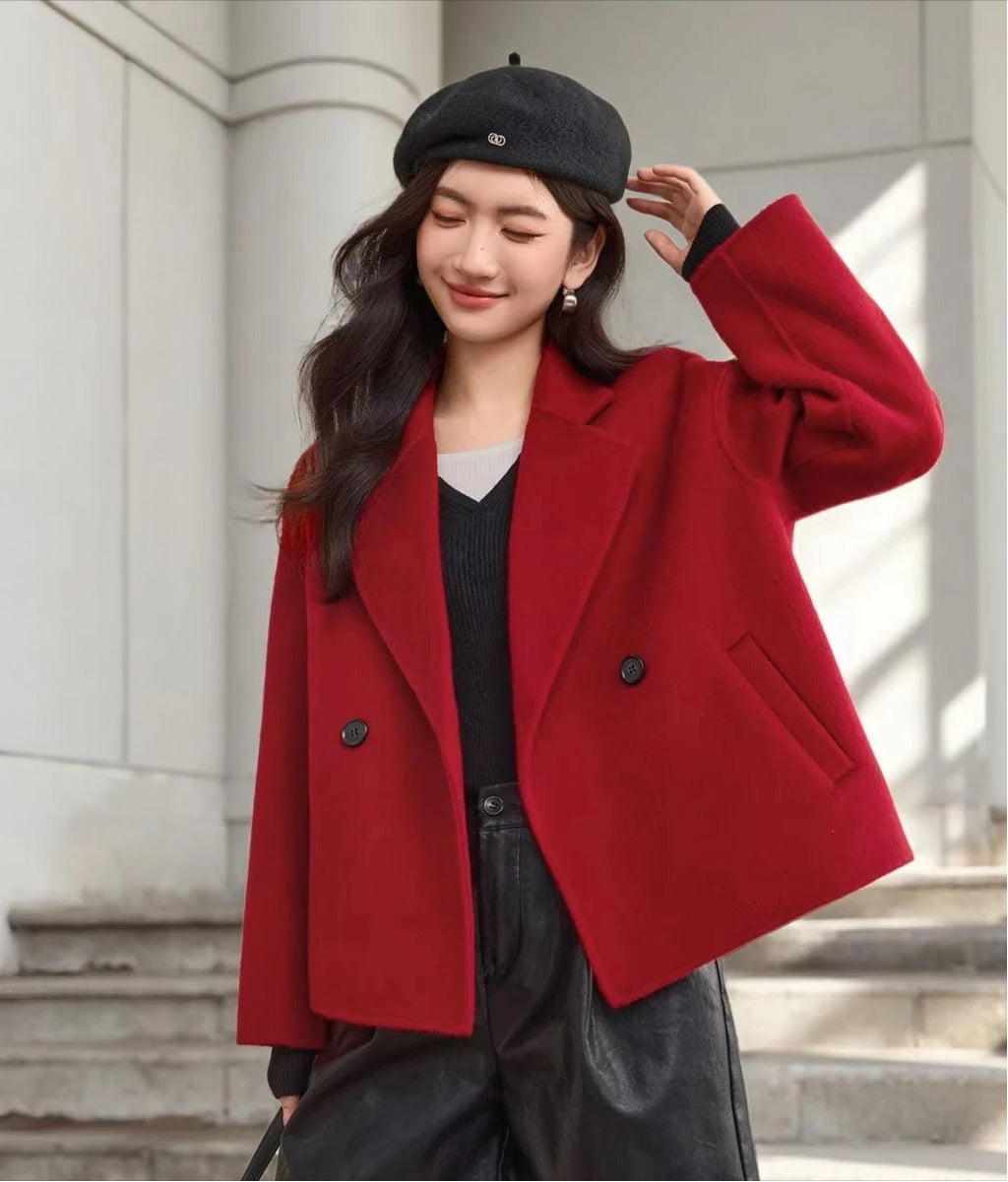 A woman adjusting her beret in a Sweet Rebellion wool jacket against a minimalist architectural background, blending fashion with structure. — From Borcelleclothes.