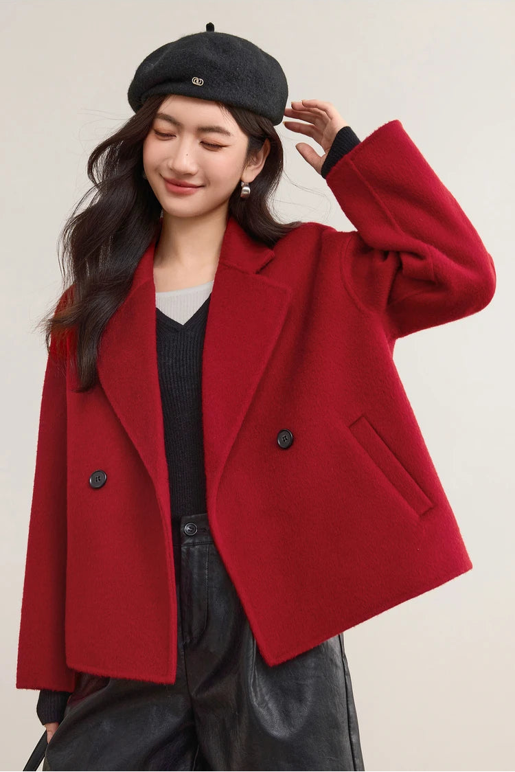 A woman in a red Sweet Rebellion wool jacket reaching up to adjust her beret, capturing a moment of effortless French chic. — From Borcelleclothes.
