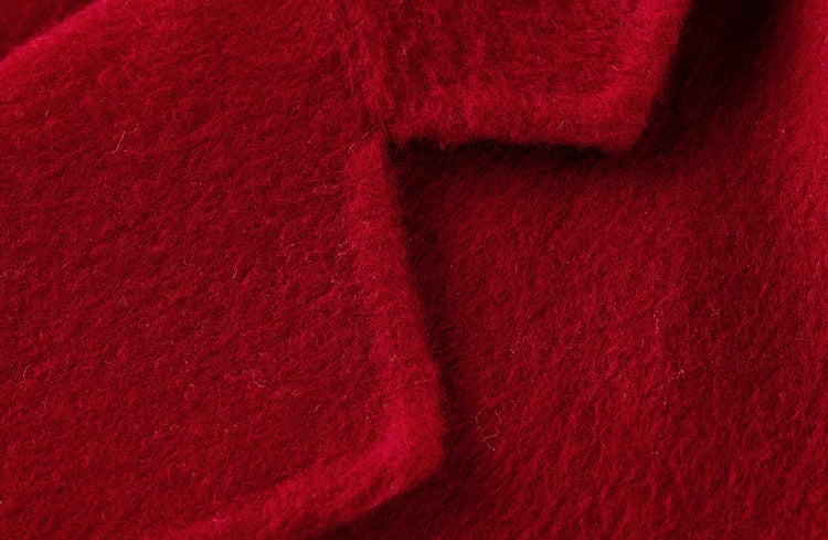 Macro shot of the notch lapel on the Sweet Rebellion red wool jacket, showing the meticulous hand-finished edges. — From Borcelleclothes.