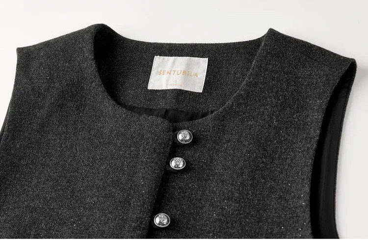 A detailed macro shot of the Improvisation vest’s upper section, focusing on the deep round neckline, the central rouleau loops, and the unique syncopated grouping of embossed silver buttons. — From Borcelleclothes.