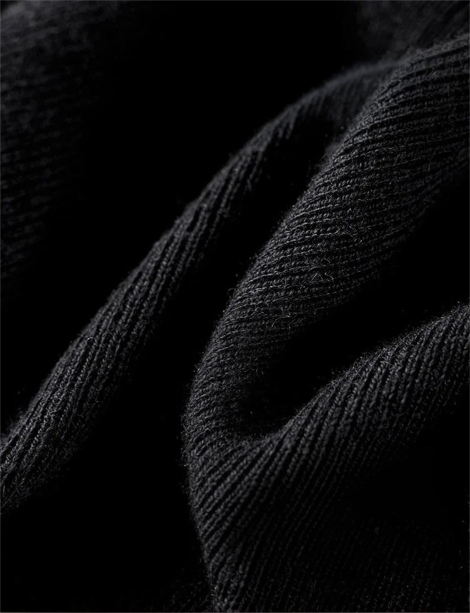 A tactile close-up of the Syncopation high-stretch black ribbed knit. The dark, folded texture captures the depth of the "quiet tone" and the subtle rhythm of the knit. — From Borcelleclothes.