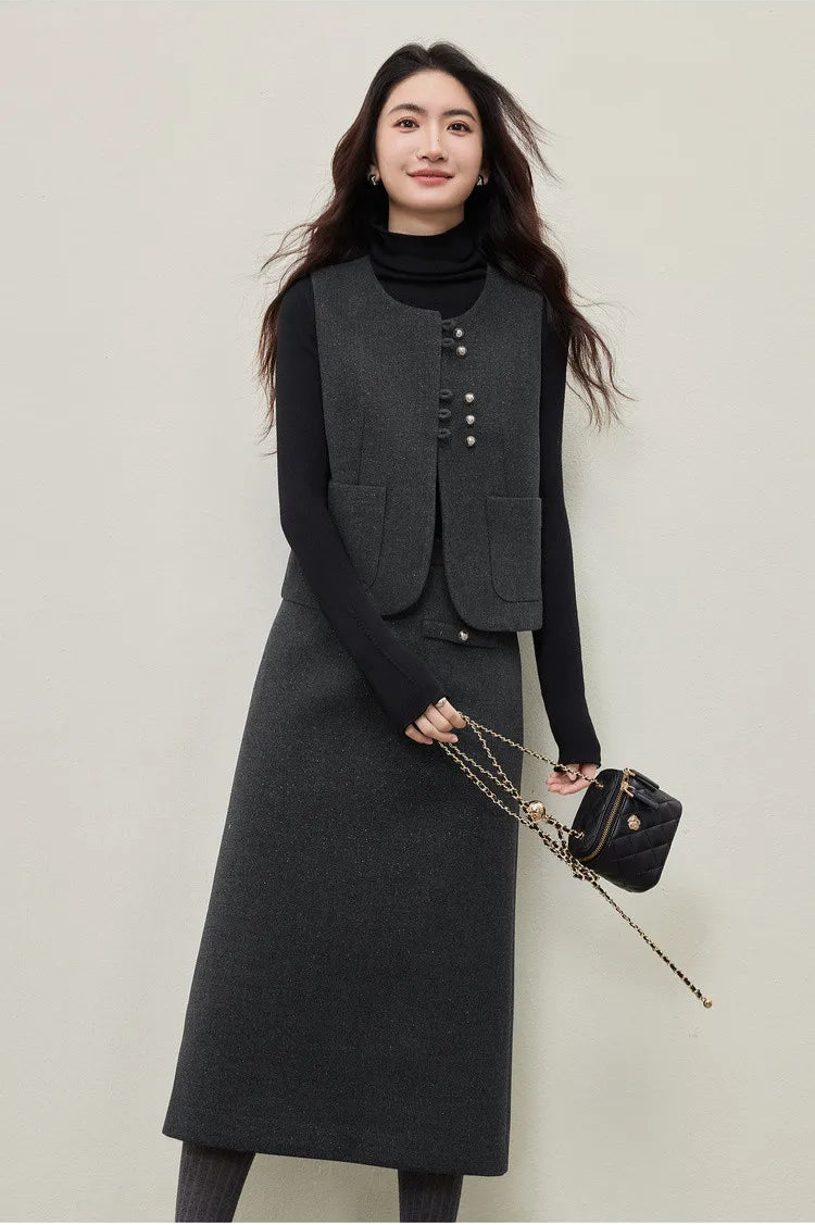 A close-up of a woman confidently holding a bag, showcasing the architectural silhouette of the Improvisation vest and the sharp, graphic vertical line of the central exposed seam on the turtleneck. — From Borcelleclothes.