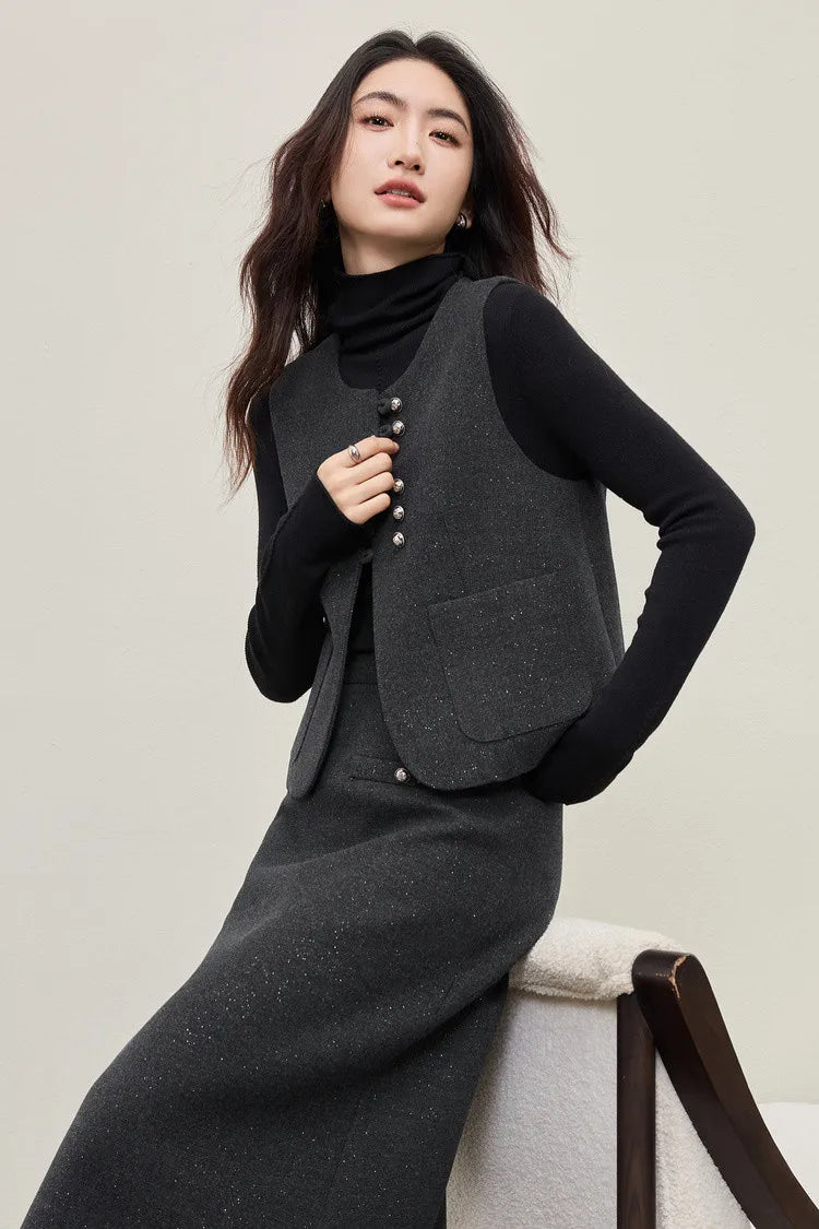 A woman in a silver-lurex three-piece office set, perching casually on the back of an armchair. The look balances the rigid structure of the vest with a spirit of ease and freedom. — From Borcelleclothes.