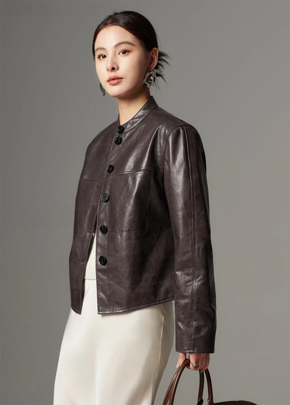 Side profile of model wearing the cropped goatskin jacket, emphasizing sleeve construction and architectural lines — From Borcelleclothes.