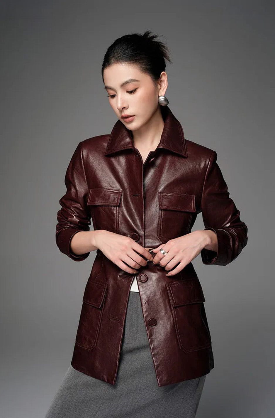 Model adjusting waist belt with both hands on Vintage Amarone sheepskin safari jacket — From Borcelleclothes.