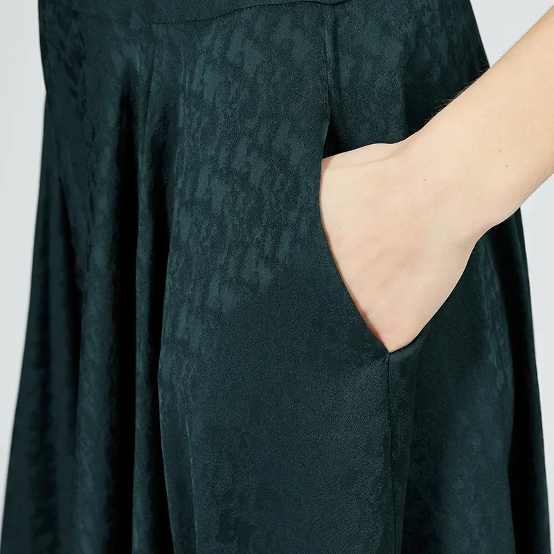 Close-up focused on a woman’s hand resting casually in the discrete side seam pocket, showcasing the refined tailoring and silk finish. — From Borcelleclothes.