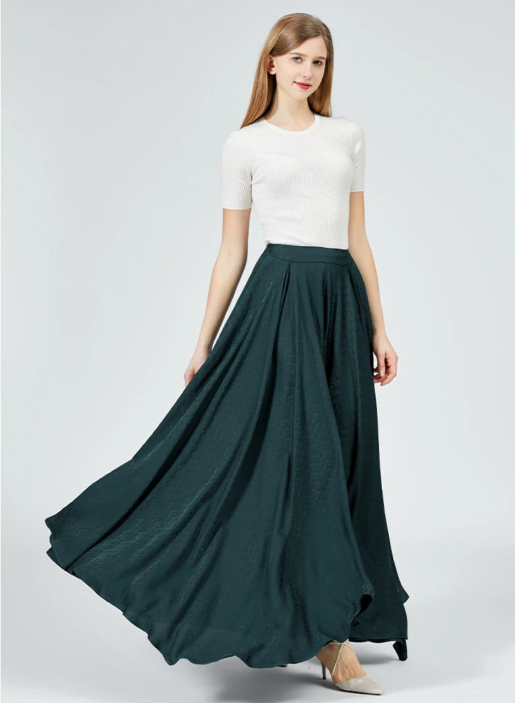 Dynamics of style: A woman shows the fluid motion and luxurious sweep of the deep emerald silk palazzo trousers as she moves. — From Borcelleclothes.