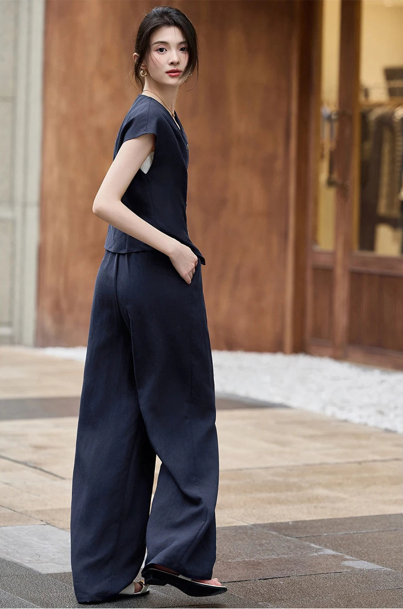 The architectural profile of the L'Oiseau Bleu set in motion, showcasing the clean lines of the wide-leg trousers — From Borcelleclothes.