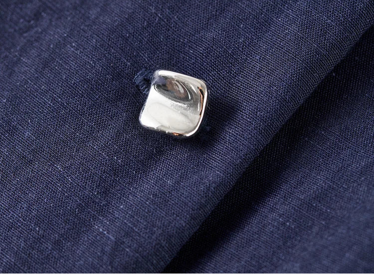 Detail of the concave silver-tone button on the L'Oiseau Bleu vest, adding a touch of industrial jewelry to the soft fabric — From Borcelleclothes.