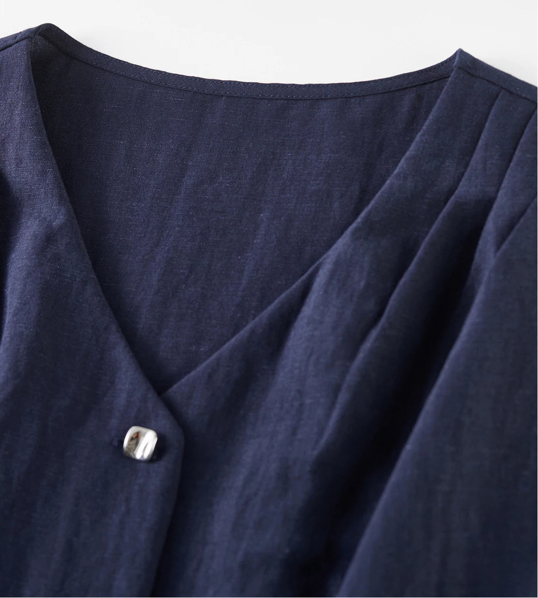 Close-up of the sculptural shoulder pleats on the L'Oiseau Bleu vest, a signature detail of Borcelle craftsmanship — From Borcelleclothes.