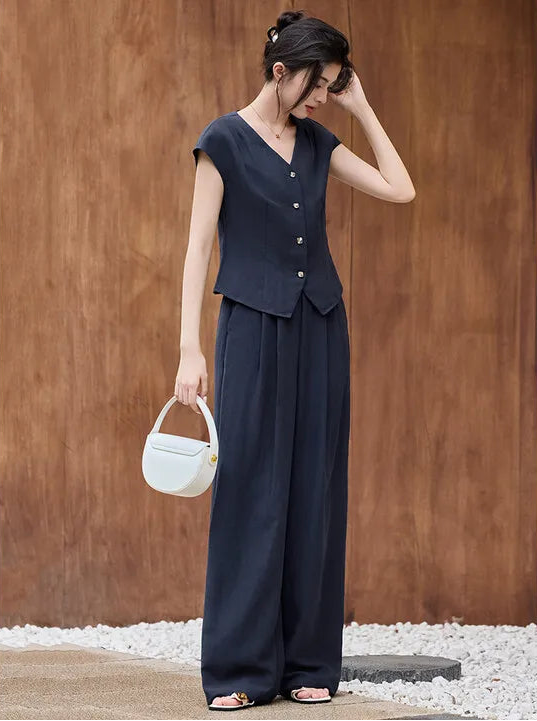 Women's set in L'Oiseau Bleu color, featuring a cropped vest with concave silver buttons and wide-cut trousers in a deep blue lyocell-linen fabric.— From Borcelleclothes.