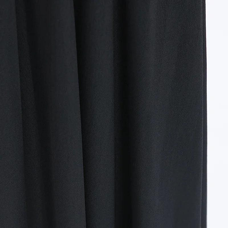 Macro shot of the heavy 40 momme Mulberry silk draping folds, capturing how the fabric weightily absorbs and reflects light — From Borcelleclothes.