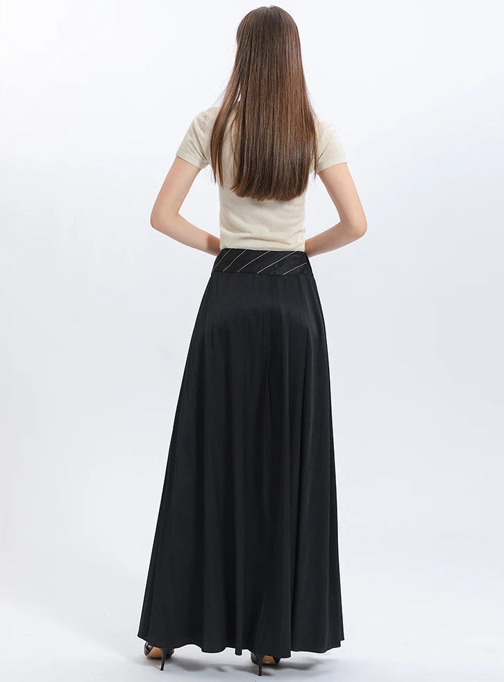 Full-height rear view of a model in the floor-length black silk skirt, displaying its flawless, long draping lines from waist to hem — From Borcelleclothes.