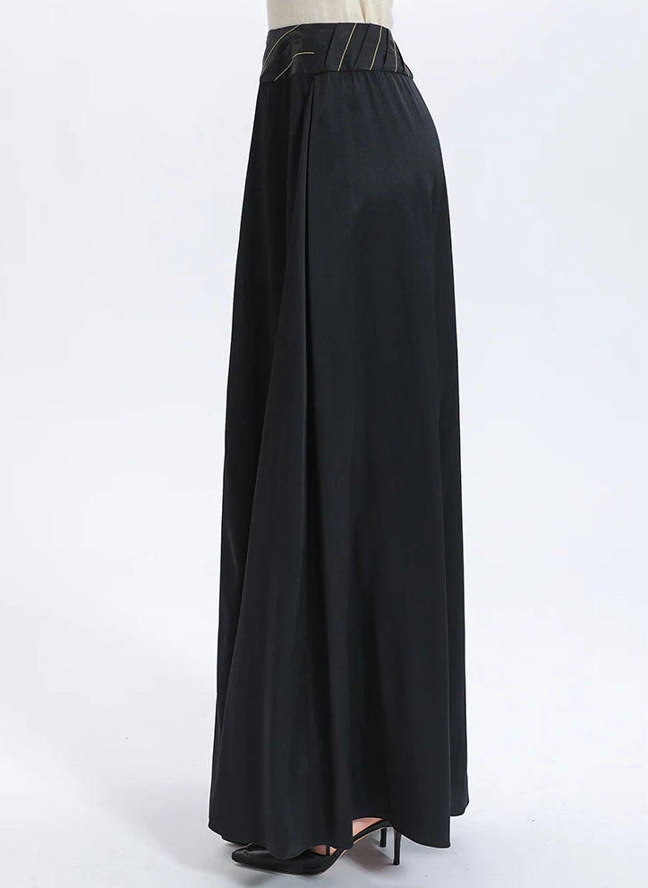 Studio side view of the pleated yoke silk skirt, accentuating the multi-layered construction and sophisticated tailoring details — From Borcelleclothes.