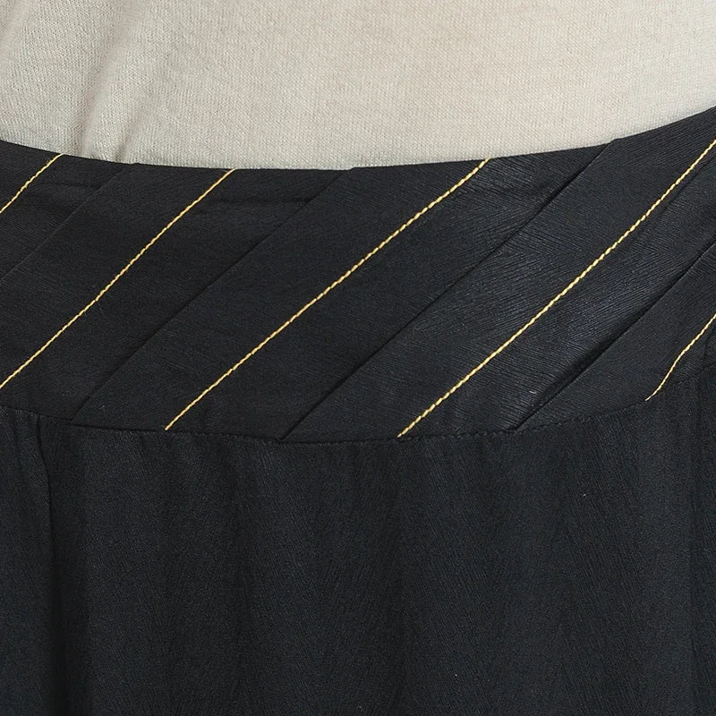 Detailed front close-up of the structured waist yoke, showcasing the pleated overlay and precise diagonal moon-colored topstitching — From Borcelleclothes.
