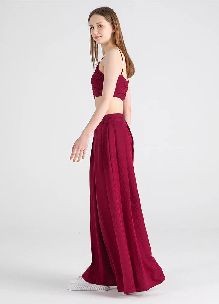 Full-height side view of a model walking in floor-length silk palazzo trousers — From Borcelleclothes.