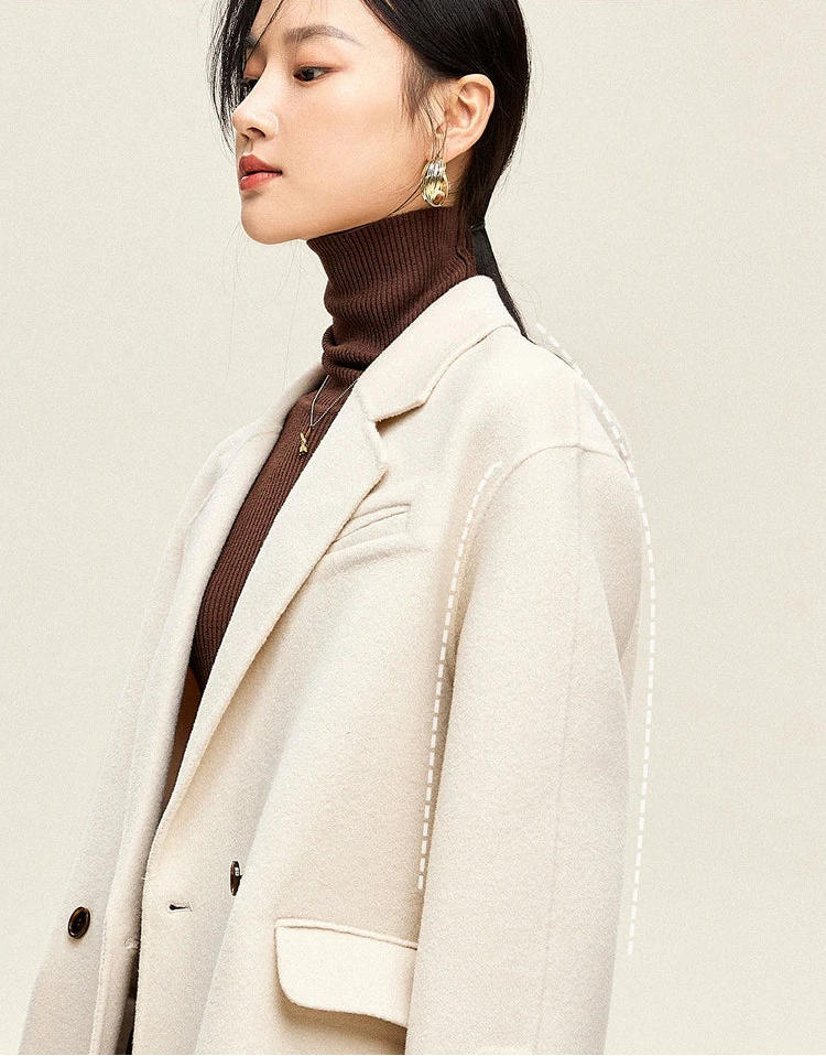 From Borcelleclothes: Side profile of a model wearing the Piano wool coat, emphasizing the dropped shoulders and the fluid, seamless fall of the double-sided fabric.